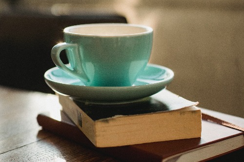 Kop koffie op twee boeken